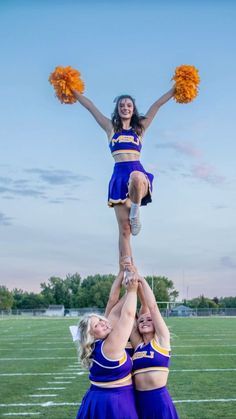 two cheerleaders doing tricks on the football field