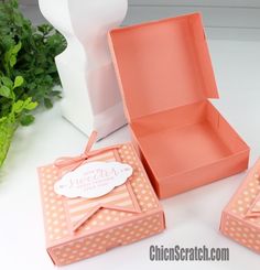 an open box sitting on top of a table next to a vase and potted plant