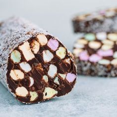 two pieces of chocolate and marshmallow cracker on a gray surface with one cut in half