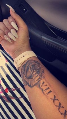 a woman's arm with a rose tattoo on it