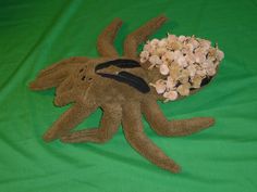 a stuffed animal laying on top of a green sheet next to a pile of flowers