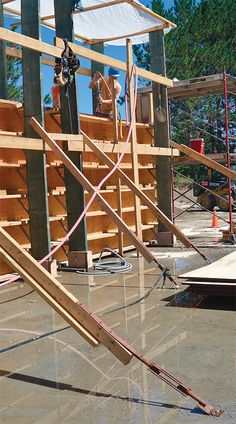 a wooden structure being constructed with tools and construction equipment on the ground in front of it