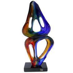 a multicolored glass sculpture sitting on top of a black base