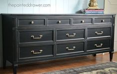 a black dresser sitting on top of a hard wood floor