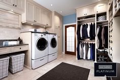 a washer and dryer sitting in a room next to some closets with clothes hanging on the walls