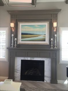 a living room with a fire place and a painting on the wall above it's mantle