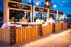 an outdoor food stand on the beach at night