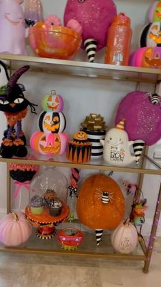 a shelf filled with lots of halloween decorations and pumpkins on top of each shelf