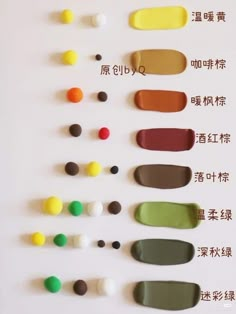 an assortment of different colored paints arranged on a white surface with chinese writing in the middle