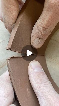 a person is making a piece of clay with their hands and thumbnails on it