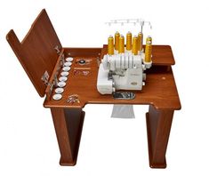 a sewing machine on a wooden table with cups