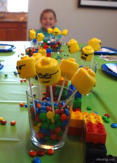 a table topped with lots of candies and lollipops next to a little boy