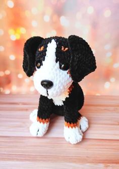 a small black and white dog sitting on top of a wooden table