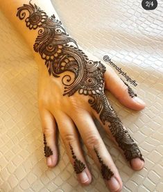 a woman's hand with henna tattoos on it