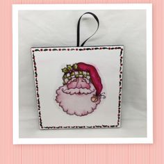 a square ornament with a santa clause on it