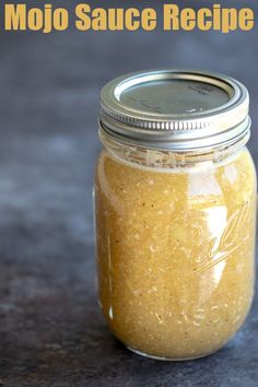 a jar filled with yellow sauce sitting on top of a table