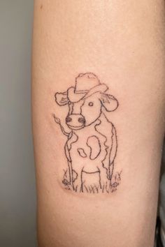 a small tattoo of a cow with a hat on it's head is shown