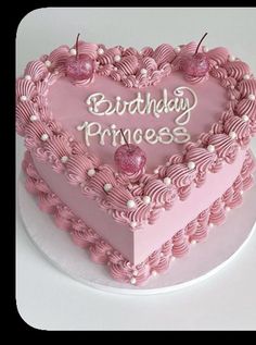 a heart shaped birthday cake with pink frosting