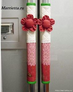 two red and white flowers are attached to the handles of a refrigerator freezer door