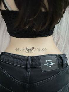 the back of a woman's stomach with a butterfly tattoo on it