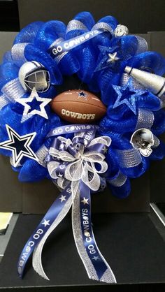 a football wreath on top of a black box filled with blue ribbon and silver decorations