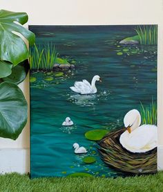 a painting of two swans and their babies swimming in the water with lily pads on the grass