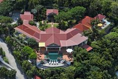 an aerial view of a house in the middle of trees and lawn chairs around it