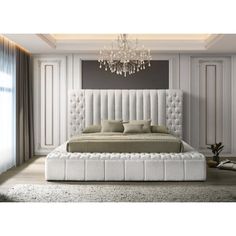 a large white bed sitting in a bedroom under a chandelier