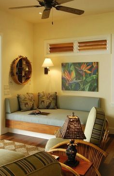 a living room filled with furniture and a ceiling fan in the middle of it's wall