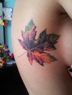 a woman's thigh with a leaf tattoo on it