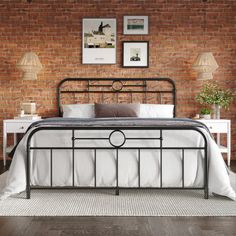 a bedroom with brick walls, white bedding and wooden flooring is shown in this image