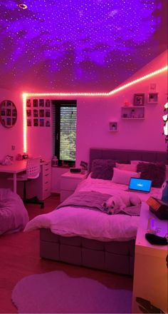 a bedroom with purple lighting and white bedding on the ceiling is lit up by colorful lights