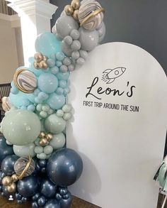 balloons are stacked on top of each other in front of a sign that says leon's first trip around the sun