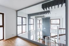 an empty room with wooden floors and large glass doors that lead to the second floor