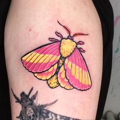 a colorful moth tattoo on the left thigh