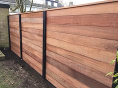 a wooden fence with black metal posts