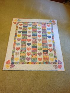 a multicolored heart quilt on the floor