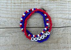 two red, white and blue beaded bracelets with the word brave written on them