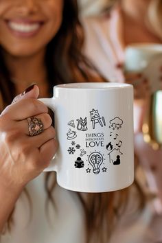 a woman is holding a coffee mug with the words things i love written on it