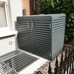 a black metal fence next to a building with a door on it's side