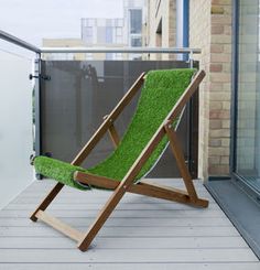 a green lawn chair sitting on top of a wooden floor next to a glass door