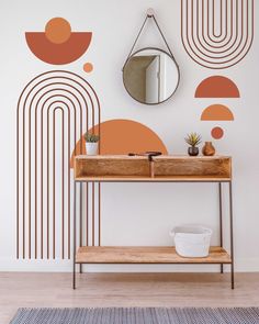 an orange and brown geometric wallpaper in a room with a wooden table, mirror and potted plant