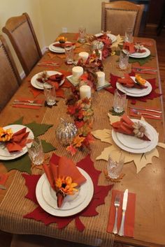 a table set for thanksgiving dinner with plates and napkins