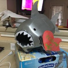 a shark with its mouth open sitting on top of a box