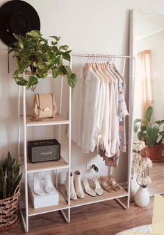 a clothes rack with shoes and hats on it in a room next to a mirror