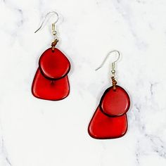 These unique guitar pic shaped earrings are handmand from the Tagua Nut in Ecuador. The harvesting of this nut helps in the preservation of the Ecuadorian rainforest and the purchase of this cllection secures amazing jobs for its artisans all over the world. Red. 1.25 inches long. Fish Hook Back. *Jewelry is not eligible for return.* Red Fair Trade Jewelry As A Gift, Artisan Red Teardrop Earrings, Guitar Pic, Guitar Pics, Unique Guitars, Tagua Nuts, Back Jewelry, Fish Hook, Ecuador