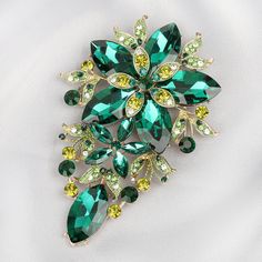 Description Turn simple into chic with a statement brooch like this Piper Floral brooch and make your own waves in fashion by bringing the brooches back. Nothing makes an outfit stand out more than an extravagant and shiny floral brooch. Large statement flower jewelry decorated with rhinestones and leaves with accenting colors with a pin backing for fabric wear. Size • Height: 5 in (12.7 cm)• Width: 3.25 in (8.26 cm) Quality Made from high-quality lightweight, solid gold coating metal alloy that Statement Brooch, Floral Brooch, Flower Jewelry, Rhinestone Brooches, Pin Backs, Green Crystals, Flower Jewellery, First They Came, Flower Brooch