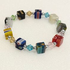 This stretch bracelet has millefiore Italian glass beads in unique cube shapes. The other beads are made of glass. This is a real arm candy! Thank you for visiting my shop! LOVE LUCK and BLESSINGS Cheap Handmade Glass Bracelets, Cube Bead Jewelry, Adjustable Glass Stretch Bracelet With Large Beads, Multicolor Square Beaded Jewelry, Adjustable Multicolor Glass Beaded Bracelets, Adjustable Multicolor Crystal Glass Bracelet, Multicolor Crystal Bracelet With Spacer Beads As Gift, Adjustable Multicolor Glass Bracelets, Adjustable Glass Bracelets With Spacer Beads