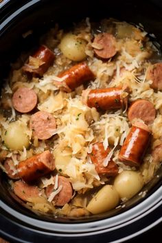 a crock pot filled with sausage and potatoes