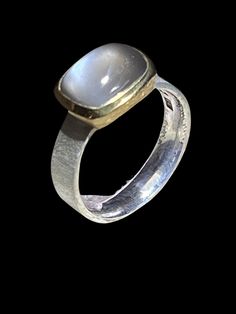 "Moonsetine gray", moonstone silver ring A mystically glowing moonstone in a cold gray stone color lets the light shimmer glide impressively over the cabochon. Interesting properties are attributed to the light varieties of moonstone. It is said to strengthen empathy and promote intuition and imagination through mystical powers. Its valuable rectangular cabochon cut makes it particularly interesting as a designer ring. Material: 925 silver, gold-plated frame Stone: Moonstone Ring size: Size 56 ( Mystical Moonstone Ring With Cabochon Cut, Mystical Moonstone Cabochon Ring, Mystical Cabochon Moonstone Ring, Modern Gold Moonstone Rings, Modern Adjustable Moonstone Gemstone Ring, Modern Adjustable Moonstone Ring, Modern White Moonstone Ring, Modern Moonstone Ring Gift, Modern Moonstone Ring As A Gift